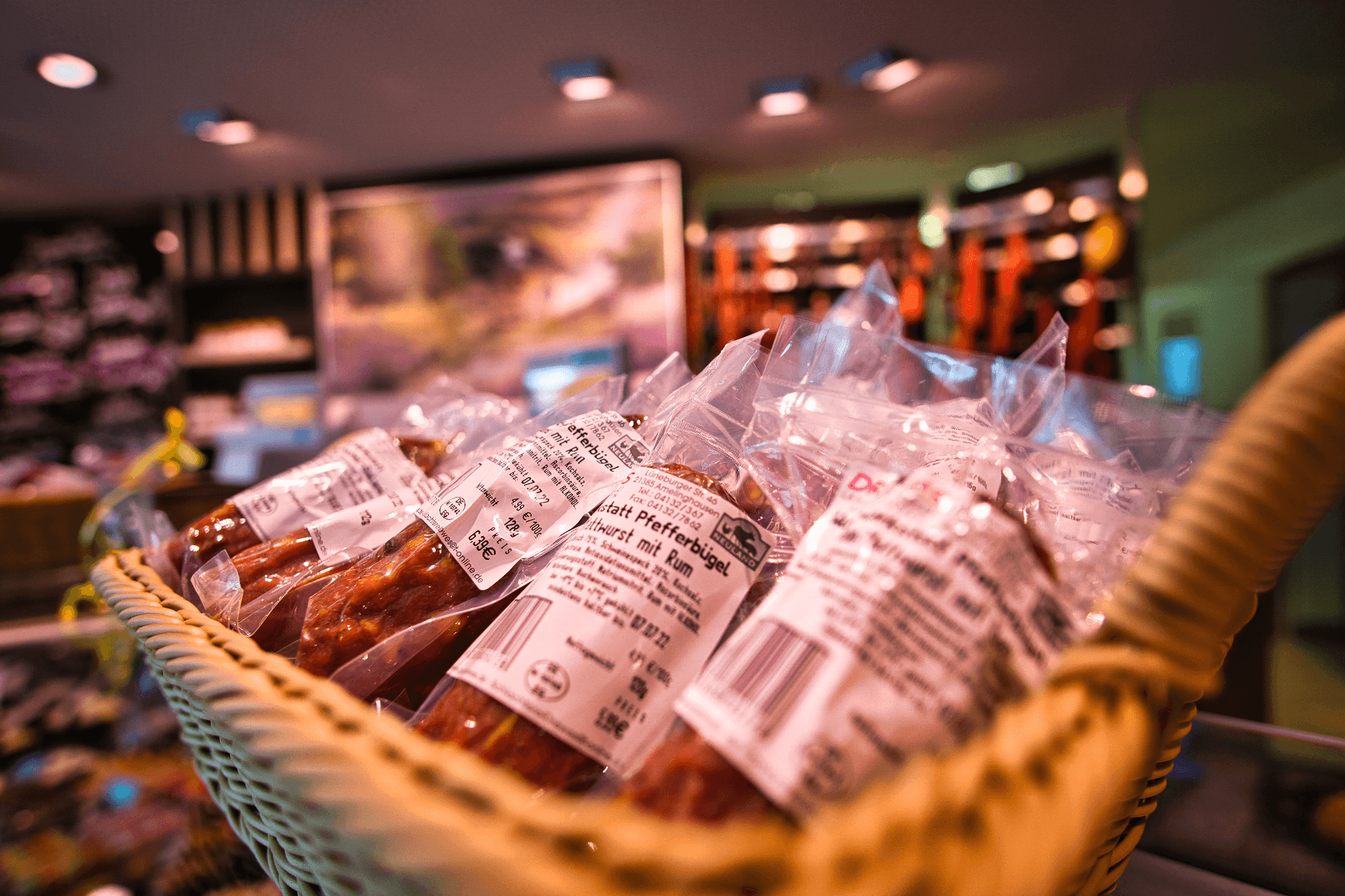 Geflochtener Korb mit verpackten regionalen Wurstwaren in einer Landschlachterei.