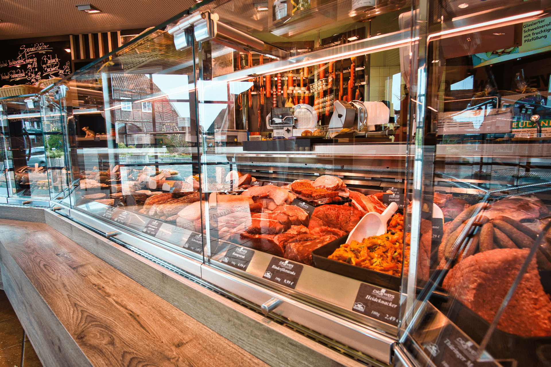 Kühltheke einer Landschlachterei mit großer Auswahl an frischem Fleisch und Wurst.