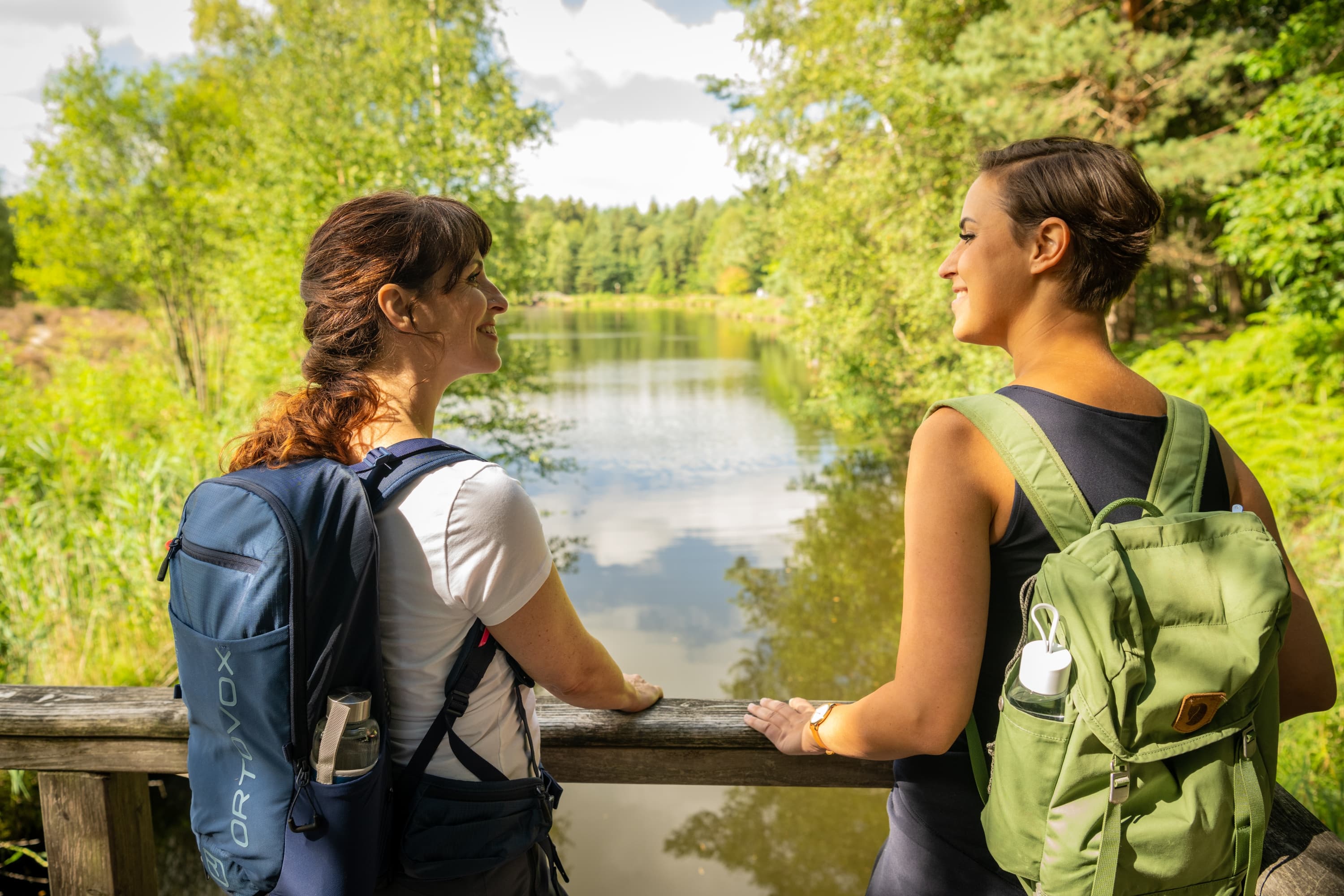 Wanderer am Angelbecksteich zur Heideblüte in Hermannsburg