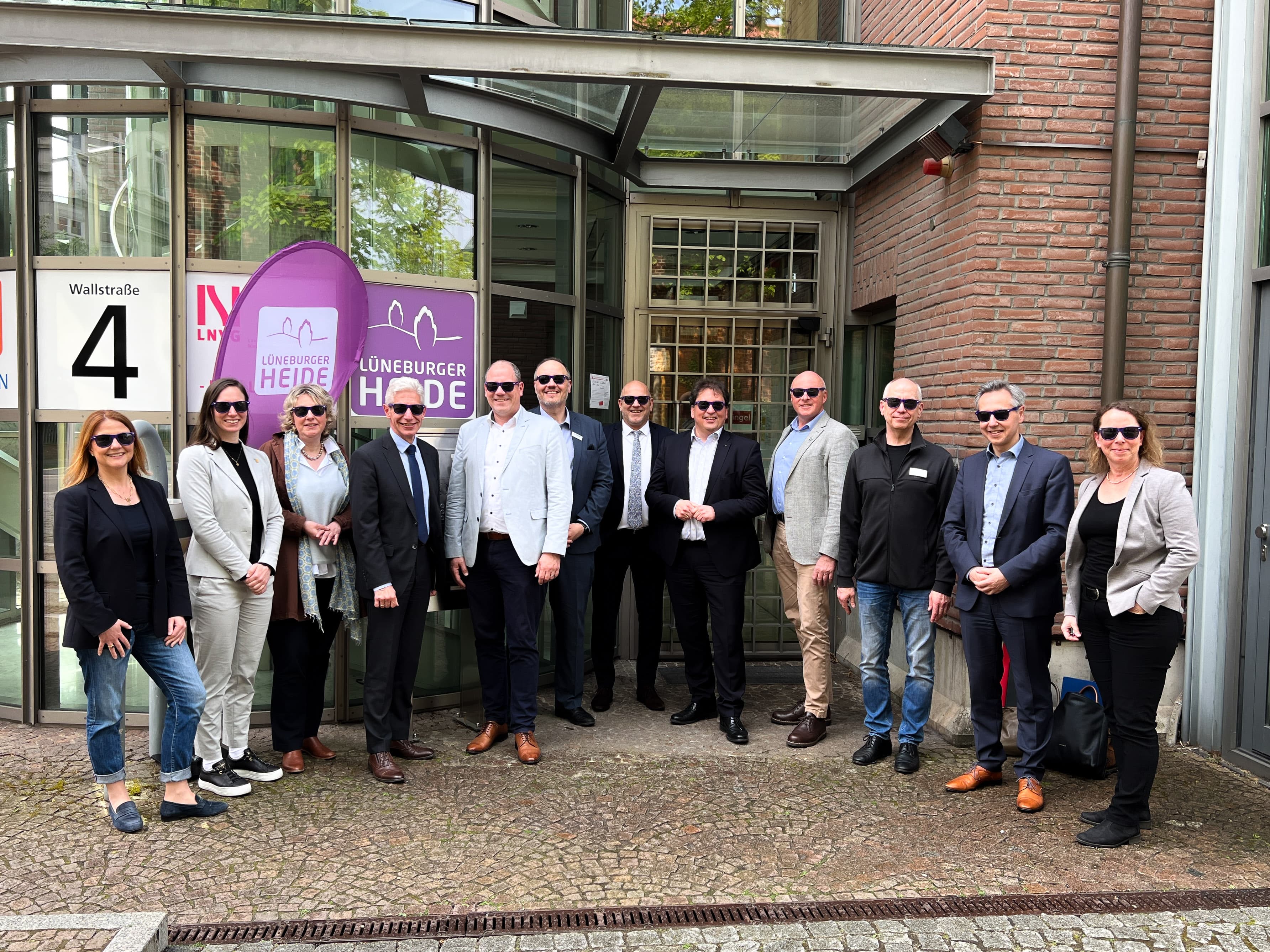 zwölf menschen acht männer vier frauen in lueneburg vor dem buero der lueneburger heide gmbh