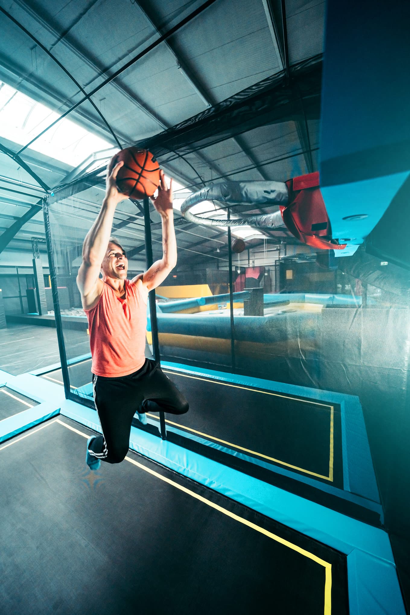 Mann springt mit Ball auf Trampolin im Abenteuerland Bispingen, ideal für Familien.Man jumping with ball on trampoline in the adventure land Bispingen, ideal for families.Mand hopper med bold på trampolin i oplevelseslandet Bispingen, ideelt for familier.Man springt met bal op trampoline in avonturenland Bispingen, ideaal voor gezinnen.