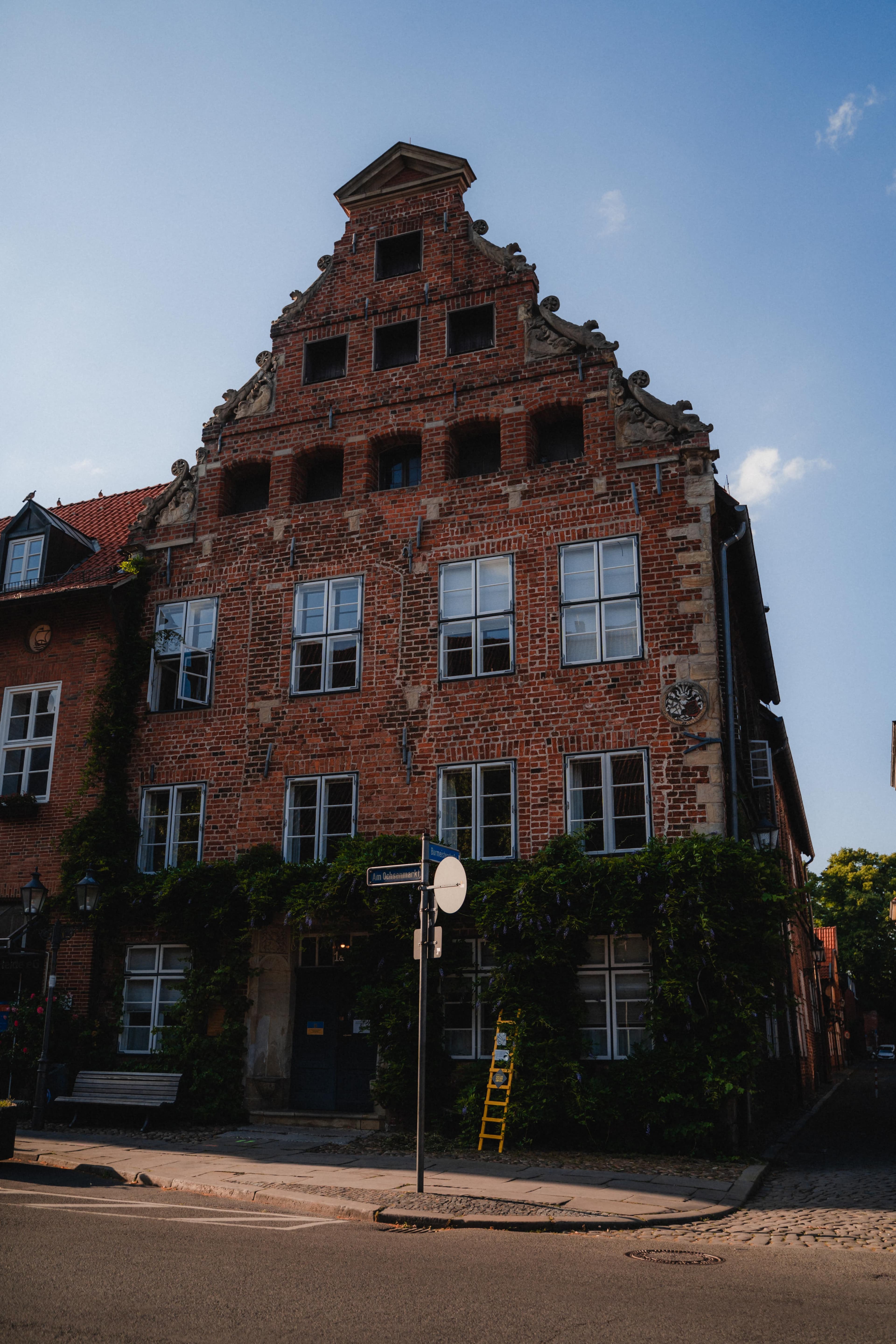 Backsteinfassade des Heinrich-Heine-Hauses mit Stufengiebel und Pflanzenranken.