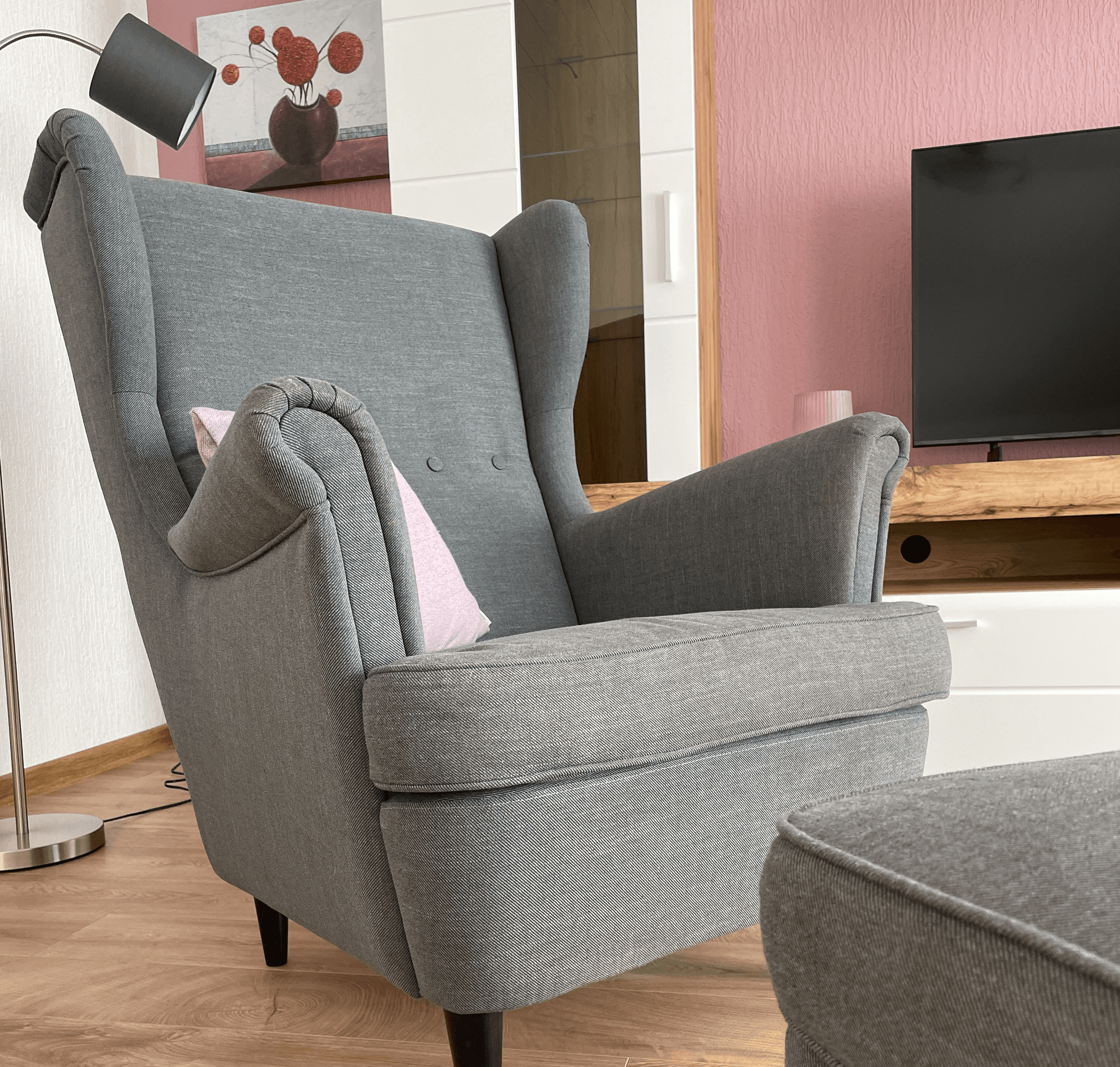 Grauer Ohrensessel mit Fußhocker