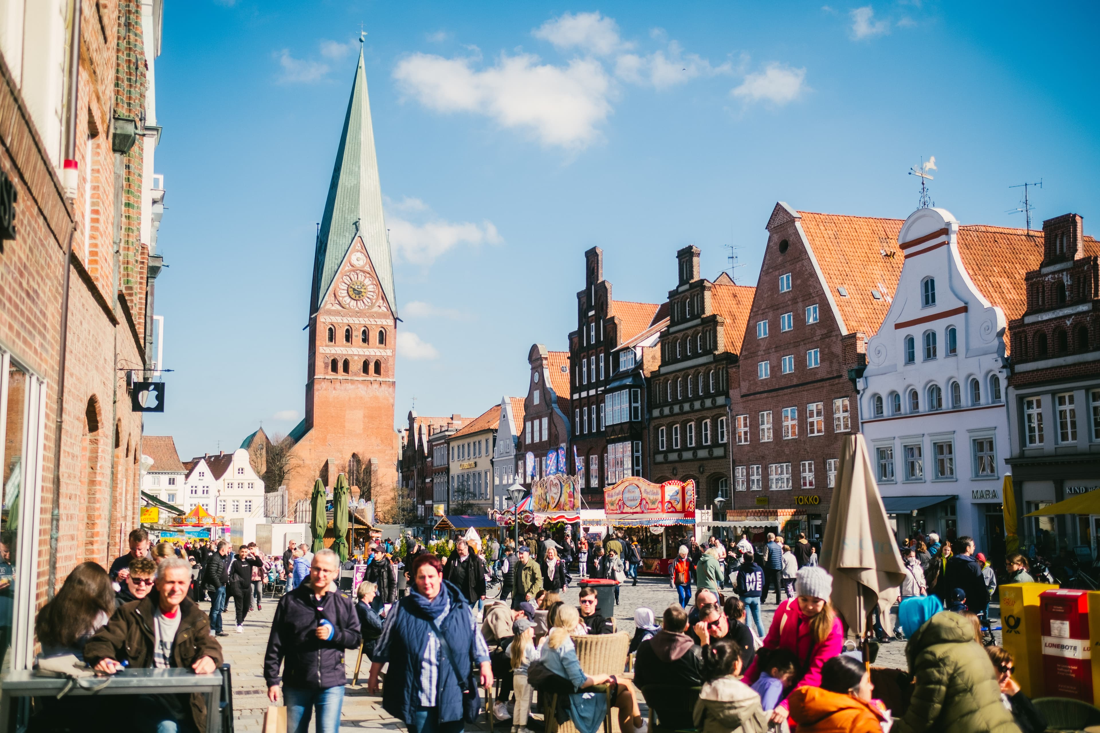 Belebter Platz Am Sande in Lüneburg mit historischen Backsteinhäusern, Kirche und vielen Menschen am Erlebnis-Sonntag.