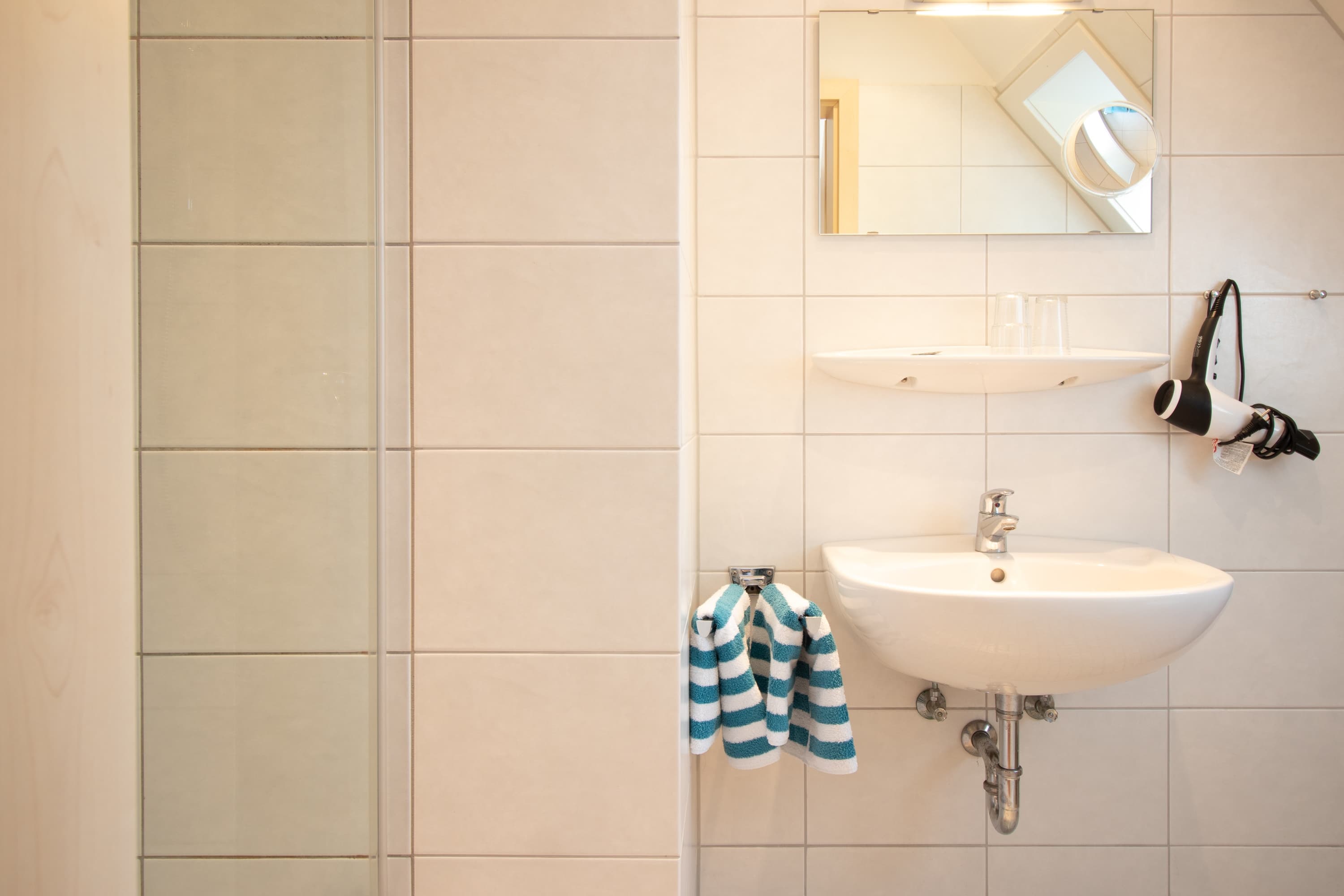 Badezimmer mit Waschbecken, Fön, Spiegel, Rasierspiegel, Handtuchhalter