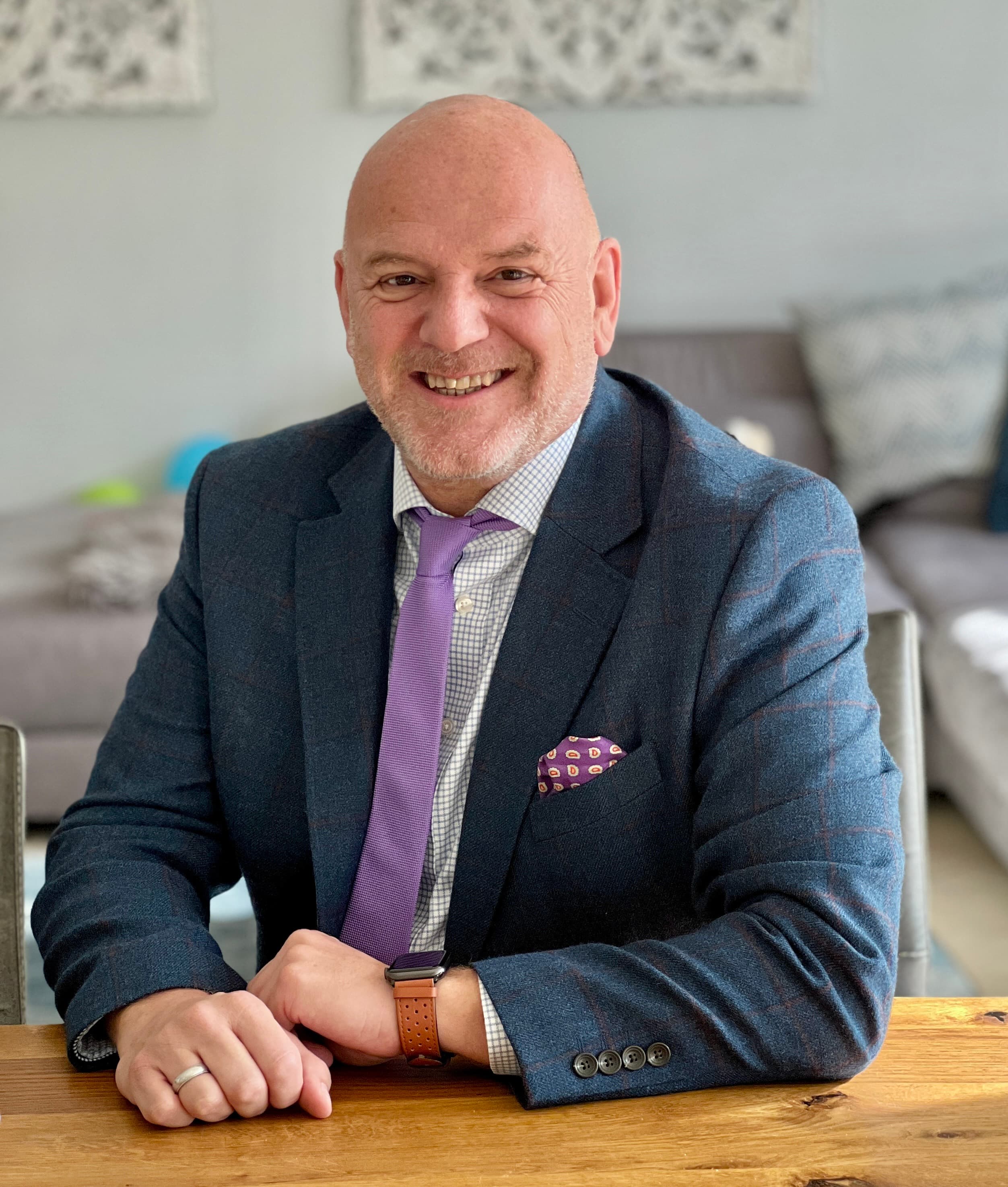 ein mann sitzt an einem schreibtisch und lächelt