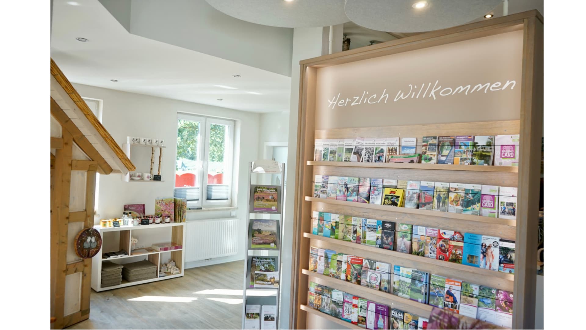 Tourist-Information im modernen Stil, mit Flyerregalen und "Herzlich Willkommen" Schriftzug.Tourist information in modern style, with flyer shelves and "Welcome" lettering.Turistinformationscenter i moderne stil med hylder til flyers og "Welcome"-bogstaver.Toeristisch informatiecentrum in moderne stijl, met folderrekken en "Welkom"-belettering.