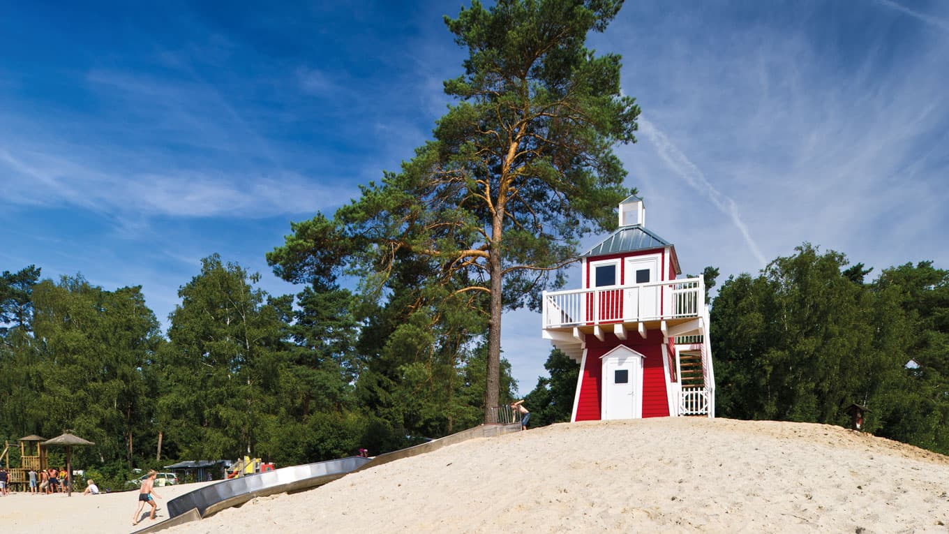 ein wahrzeichen des südsee camps ist der leuchtturm am see