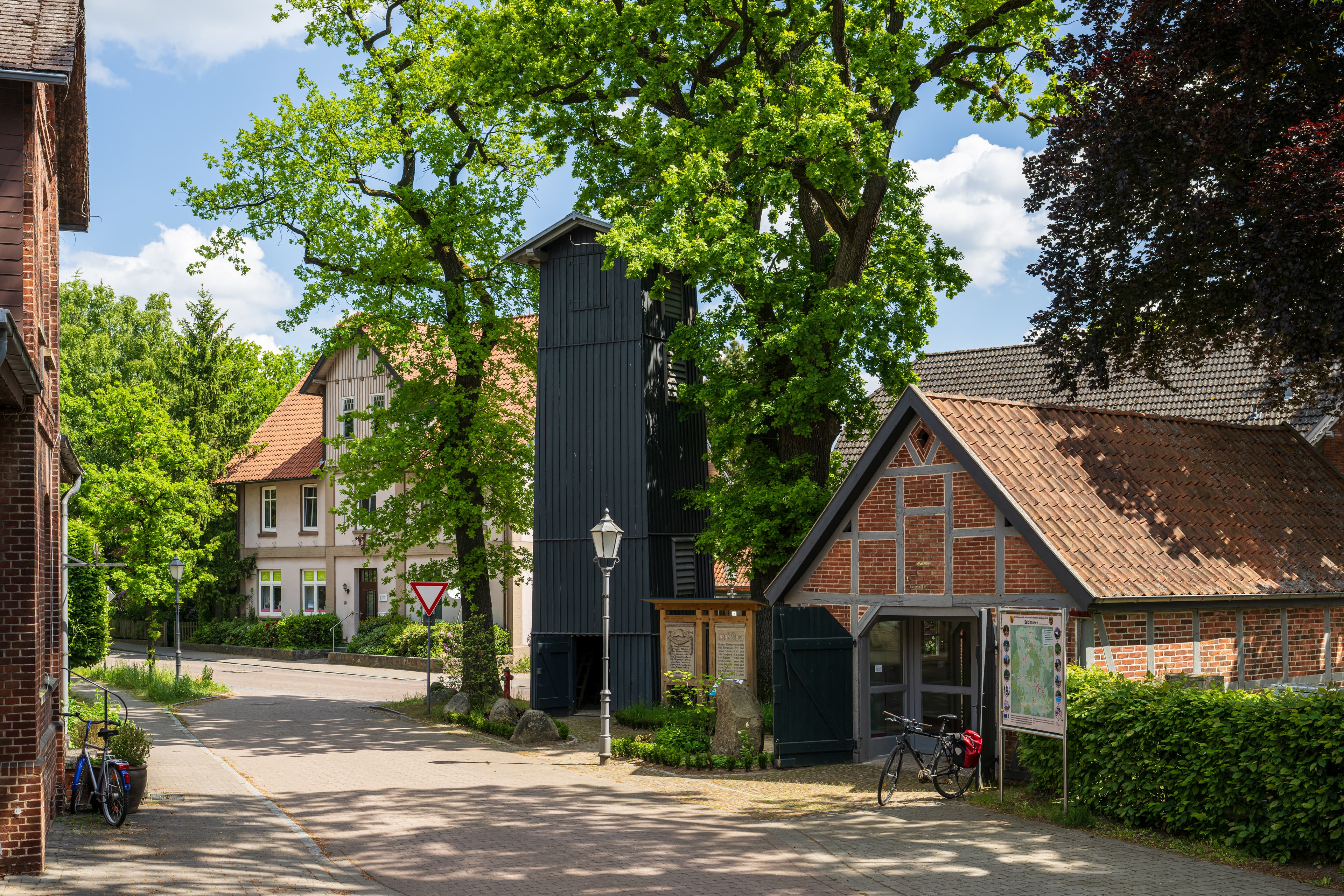 Dunkler hölzener Schlauchturm in der Dorfmitte