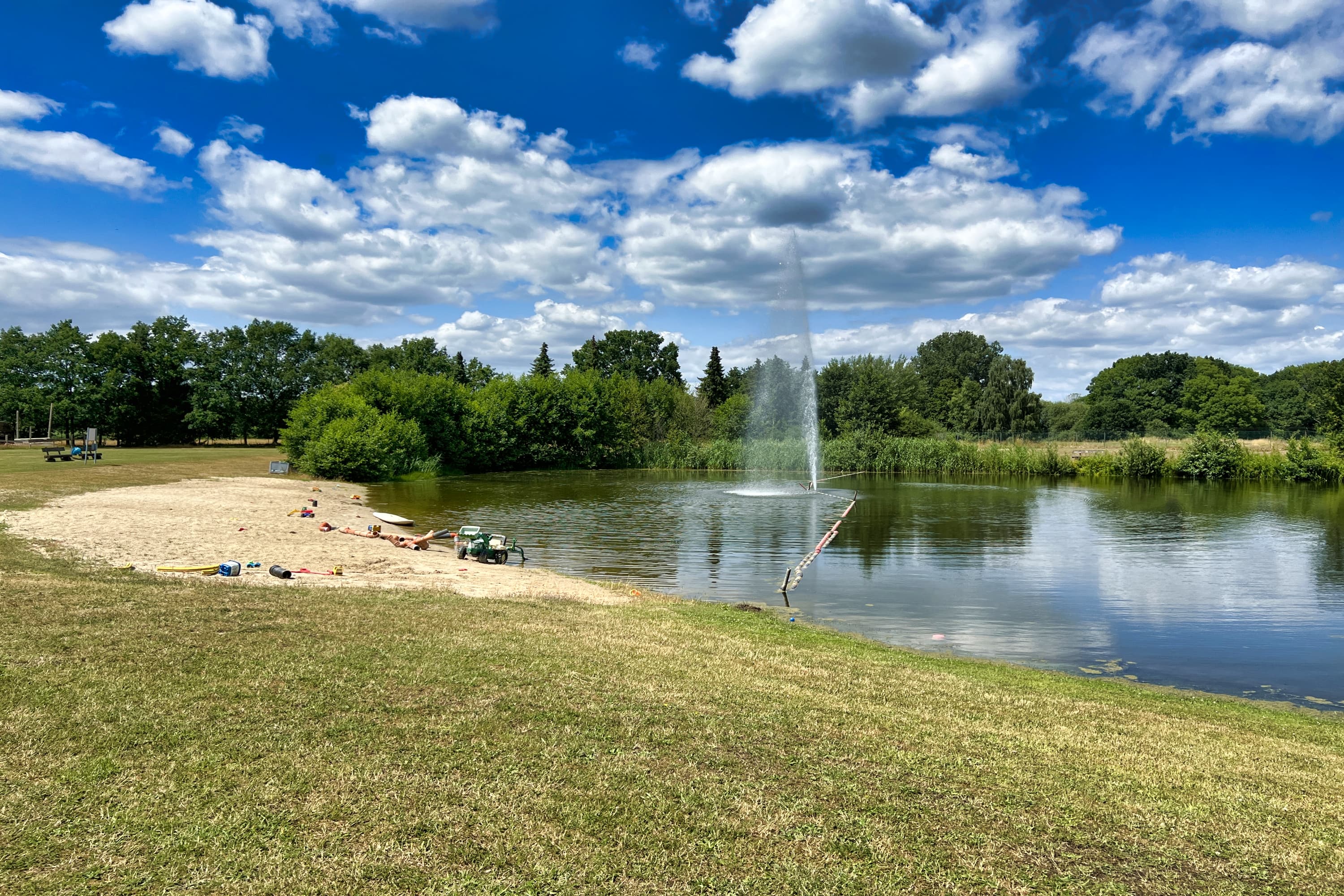 Das Strandbad in Langlingen mit Liegeflächen auf der Wiese und Sandstrand