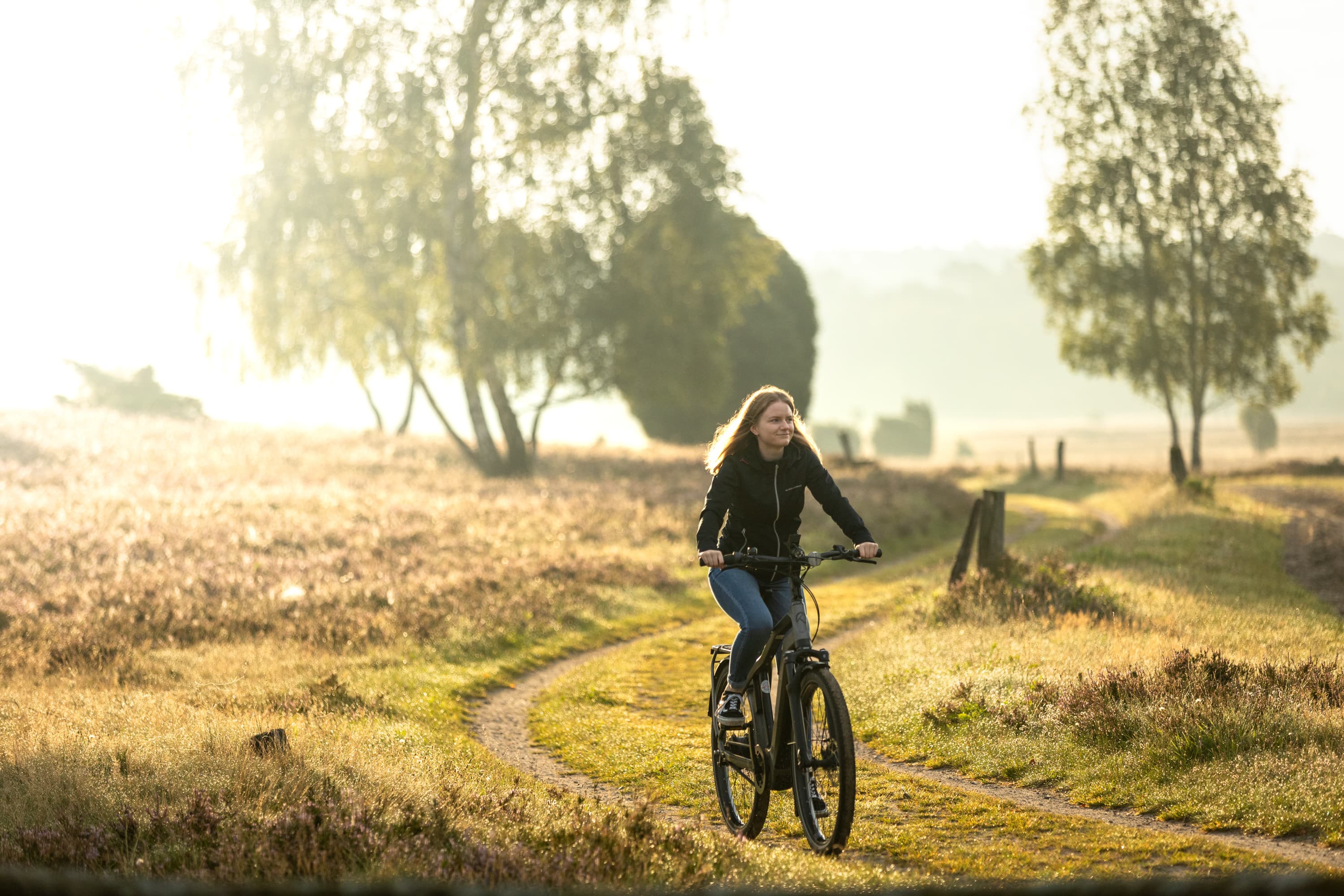 Fahrradfahrerin fährt mit einem Leihfahrrad durch die Lüneburger Heide