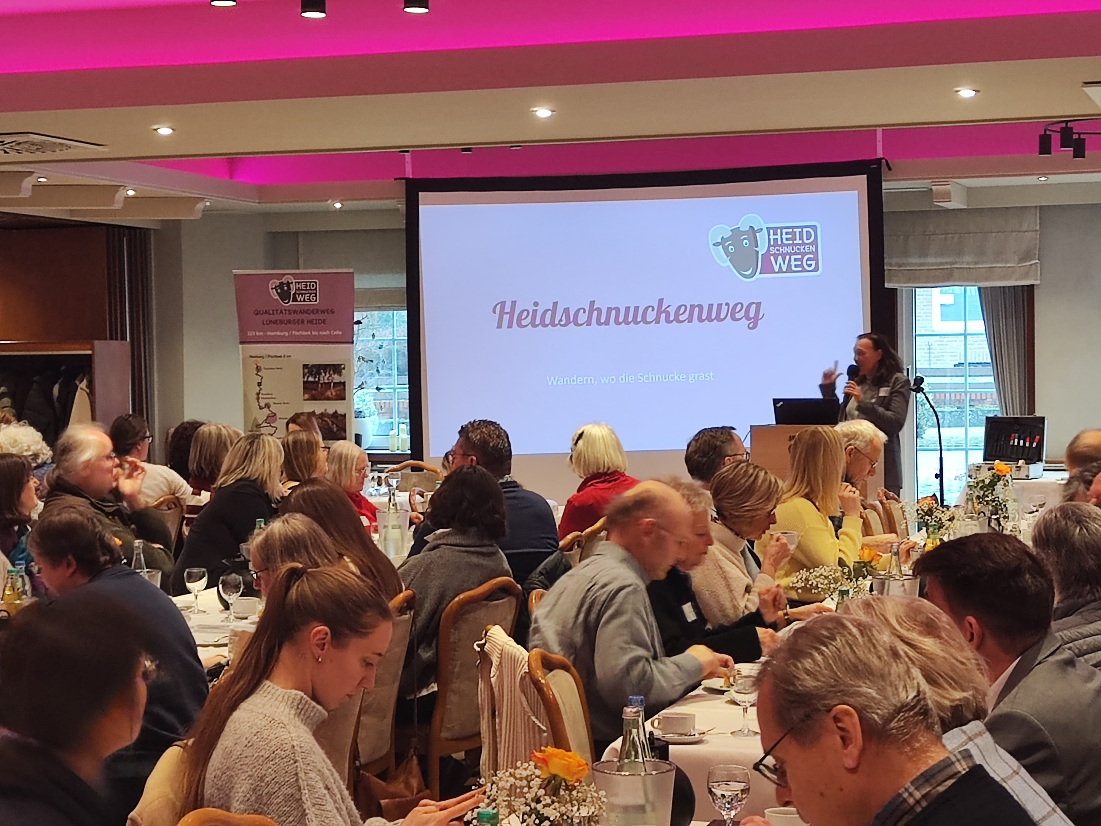 eine gruppe menschen hört sich einen vortrag an