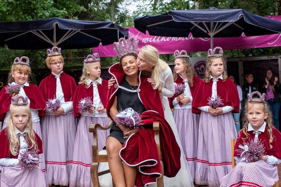 Die glückliche neue Heidekönigin bekommt von ihrer Vorgängerin Mantel und Krone.